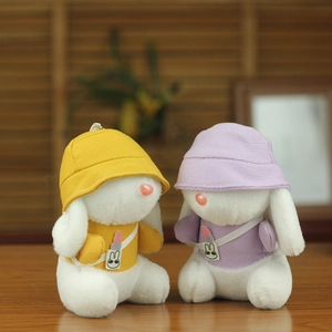 Dettaglio di portachiavi a forma di coniglio in peluche giallo e viola su tavolo in legno