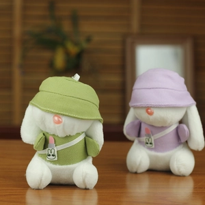 Dettaglio di portachiavi a forma di coniglio di peluche verde e viola con cappelli