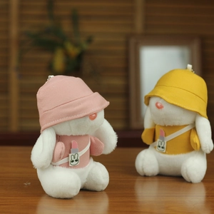 Dettaglio dei ciondoli a forma di coniglio di peluche rosa e gialli con cappelli e borse