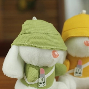 Dettaglio del portachiavi a forma di coniglio in peluche con cappello e borsa verde