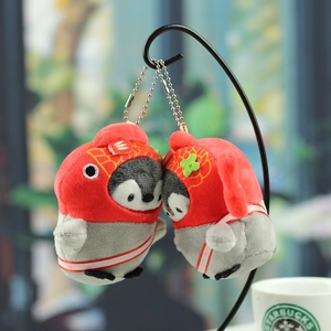 Plush penguin keychain charms with red koi fish and lucky cat hats on a metal stand