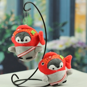 Detail of plush penguin keychains with red koi fish hats and soft grey-white fabric textures