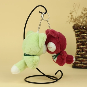 Gros plan de porte-clés ours en peluche mignons en vert et bordeaux avec anneaux métal