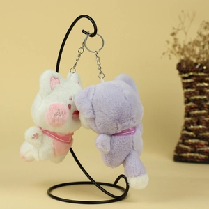 Détail de porte-clés chat en peluche blanc et violet avec broderie cœur et écharpe