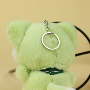 Détail de l'arrière d'un pendentif chat en peluche vert clair avec un anneau métallique argenté