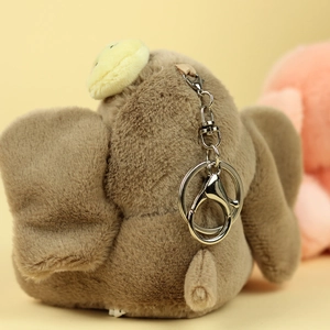 Dettaglio di un portachiavi a forma di elefante in peluche marrone con chiusura in metallo
