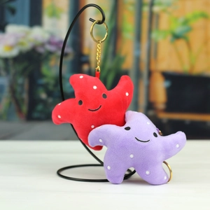 Détail de porte-clés peluche étoile de mer colorés avec broderie et anneaux dorés