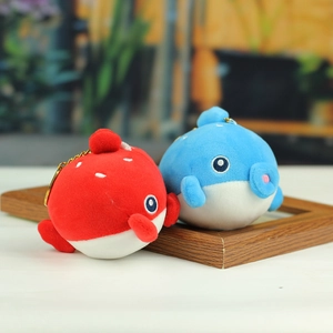 Gros plan de porte-clés baleines en peluche bleu et rouge avec chaînes en métal doré