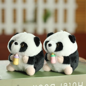 Cute plush panda dolls with milk bottles sitting on books in a warm garden setting