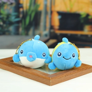 Détail de pendentifs en peluche dauphin et poisson avec porte-clés dorés élégants