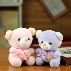 Cute pink and purple plush bears with Love You heart embroidery and plaid bows on wood table