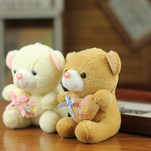 Detail of plush teddy bears in cream and brown with LOVE YOU heart and plaid bows
