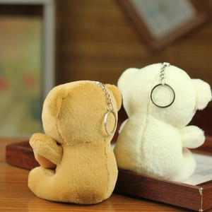 Rear view of cute plush bears in brown and cream white with silver metal keychains