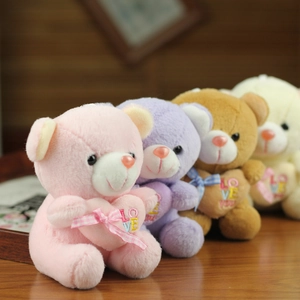Close-up of colorful plush teddy bear charms with Love embroidery and plaid bows