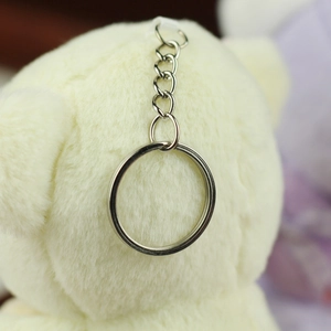 Close-up of the polished silver metal keychain attachment on a plush teddy bear toy