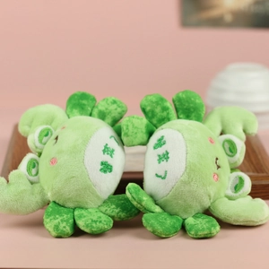 Detail of plush crab pendants with fortune embroidery and soft green textured fabric