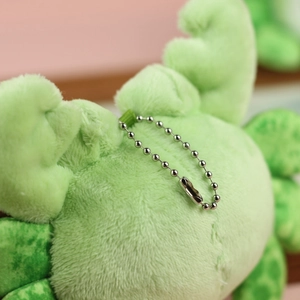 Close-up of the metal bead chain attachment and plush fabric on green crab charm