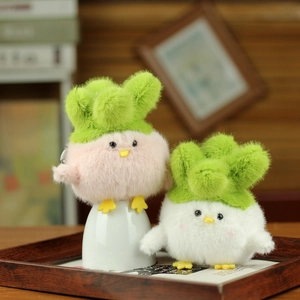 Close-up of plush chicken keychains in cabbage hats on a cozy wooden tray