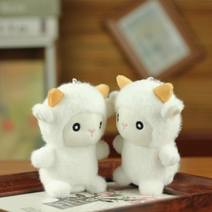 Dettaglio di una coppia di graziosi portachiavi a forma di pecora in peluche bianco morbido