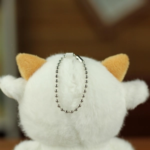 Dettaglio del retro di un portachiavi a forma di pecora in peluche con catenella d'argento