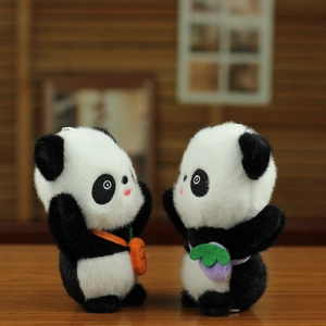 Detail von Panda-Plüschanhängern mit Karotten- und Fruchttaschen auf einem Holztisch