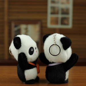 Nahaufnahme von Panda-Plüschanhängern mit weichem Kunstfell und Metallring auf Holz