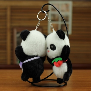Nahaufnahme von Panda-Plüsch-Anhängern mit Erdbeere und silbernen Metall-Schlüsselanhängern