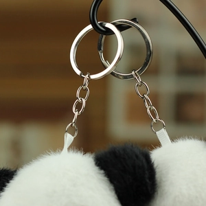 Detail eines weichen schwarz-weißen Panda-Plüsch-Schlüsselanhängers mit silbernem Metallring