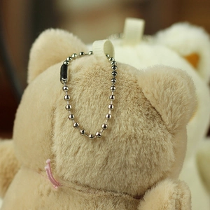 Close-up of soft khaki plush bear pendant with durable silver bead chain for bags