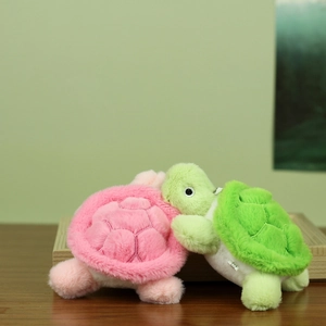 Close-up of pink and green plush turtle keychains with soft texture and shell details