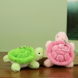 Detail view of plush turtle keychains in pink and green with soft quilted shell texture