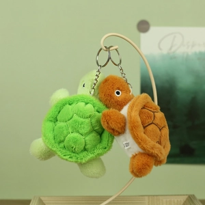 Detailed view of green and brown plush turtle keychains hanging on a display stand