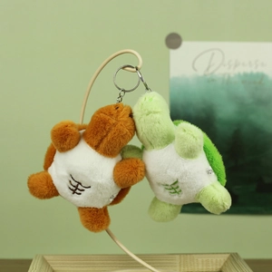 Detailed view of two cute plush turtles with abs embroidery and metal keychains