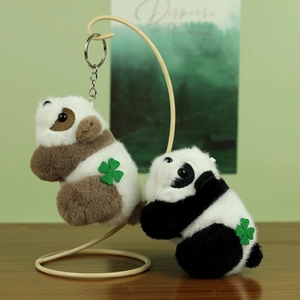 Close-up of cute panda plush keychain with four-leaf clover on a metal display stand