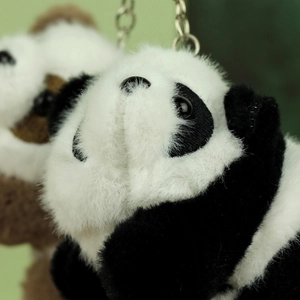 Macro detail of soft plush panda keychain showing furry texture and cute facial features