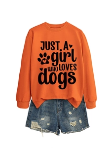 Detail of orange sweatshirt with JUST A girl WHO LOVES dogs print and denim shorts
