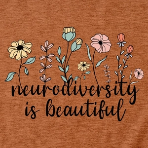 Macro detail of the Neurodiversity is Beautiful text and floral print on rust red t-shirt