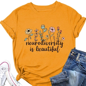 Flat lay of orange neurodiversity is beautiful t-shirt with floral print and casual denim