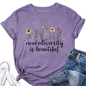 Flat lay of purple cotton T-shirt featuring flower art and neurodiversity slogan