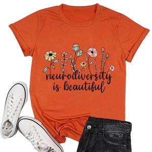 Flat lay of orange neurodiversity is beautiful t-shirt with floral print and denim shorts
