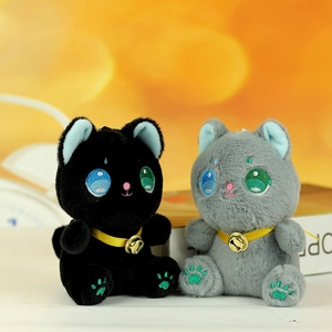 Dettaglio di gattini di peluche con occhi ricamati, campanelli dorati e zampe colorate