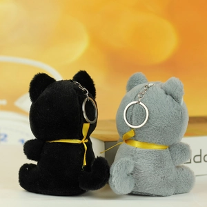 Vista posteriore di portachiavi a forma di gatto in peluche nero e grigio con nastri