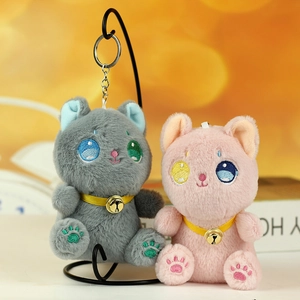 Dettaglio di portachiavi gatto in peluche con ricami e piccoli campanellini