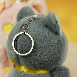 Dettaglio ravvicinato del portachiavi a gatto in peluche grigio scuro con anello in argento