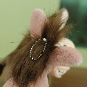 Détail de porte-clés âne en peluche rose avec crinière brune et chaîne à billes en métal