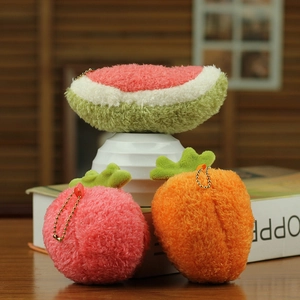 Close-up of plush fruit pendants featuring watermelon, peach, and carrot with gold chains