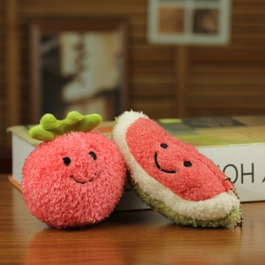Detailed plush strawberry and watermelon slice keychains on a rustic wooden table