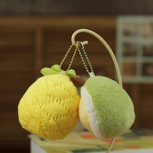 Detail of plush pineapple and durian keychains with textured fabric and bead chains
