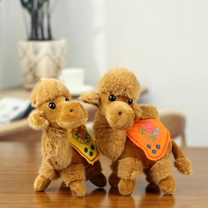 Plush camel keychain with ethnic embroidery shown on a wooden desk in home setting