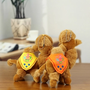 Detail of plush camel keychain with folk embroidery saddle and metal ball chain